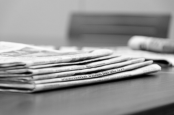 Stapel Zeitungen auf Tisch